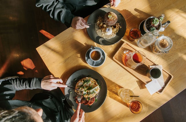 Birdseye view of a sweet and a savoury brunch dish, an espresso and a pour over coffee as well as table condiments at C4.