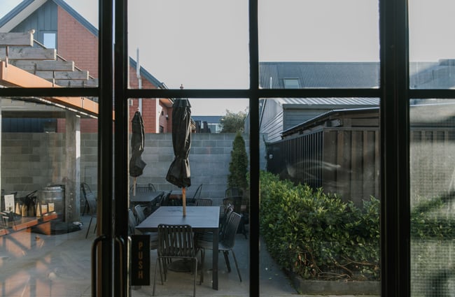 View of the outside courtyard through a window inside C4 Coffee.