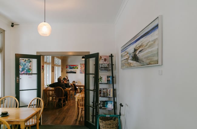 A small dining room with magazines on a rack at Café Verde in Geraldine.