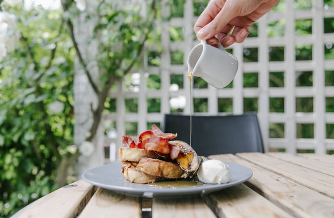 Maple syrup being poured onto French Toast with bacon at Café Verde in Geraldine.