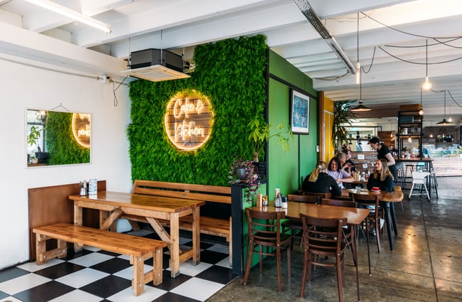 A fake living wall inside a brightly lit cafe.