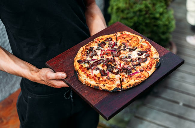 Pizza on a wooden board at Cambridge Lane.