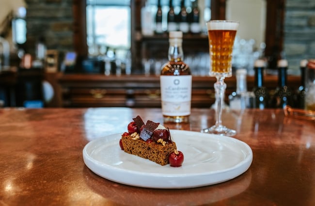 A dessert dish and whisky cocktail on a dining table at Cardrona Distillery.
