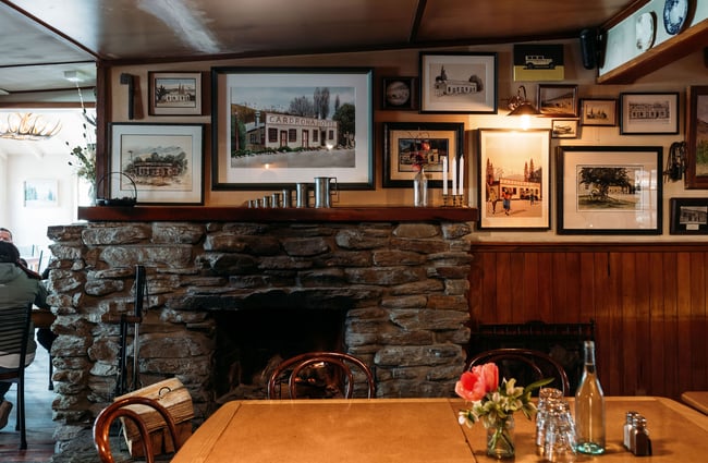 Stone fireplace and hearth inside Cardrona Hotel dining area.
