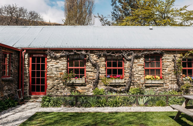 An exterior door to the hotel reception at Cardrona Hotel with flowerboxes underneath the adjacent windows.