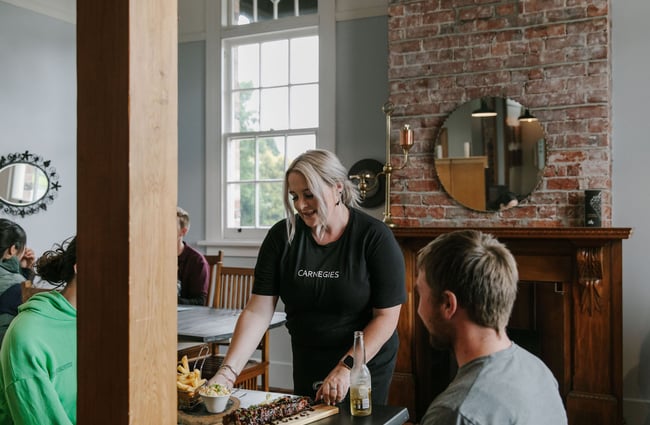 Waitress serving a table at Carnegie's Restaurant and Bar, Fairlie.