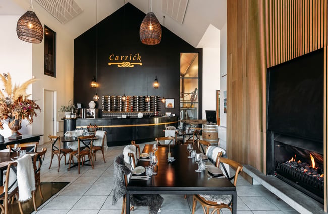 A fireplace and seating inside Carrick Wines.