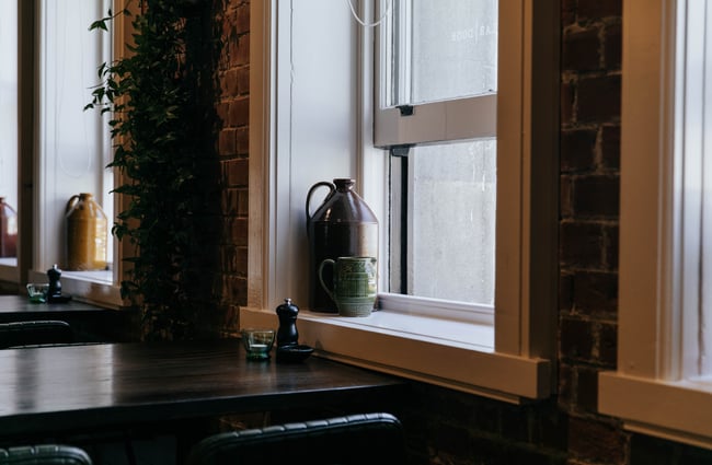 Flagon of water sitting in a window at Cellar Door in Christchurch.