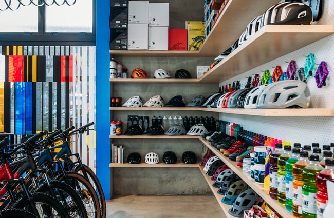 Helmets lined up on the wall and bikes beside them at Central Bicycle Studio.