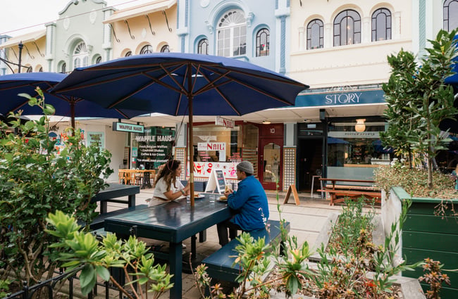 Two customers sitting outside on New Regent Street surrounded by plants.