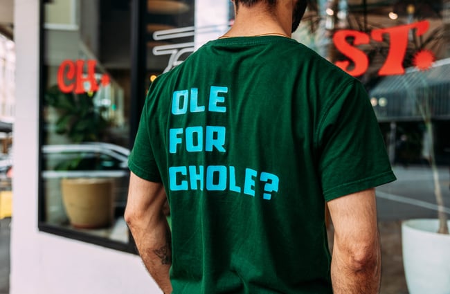 A back of a t-shirt with the words 'ole for chole?'