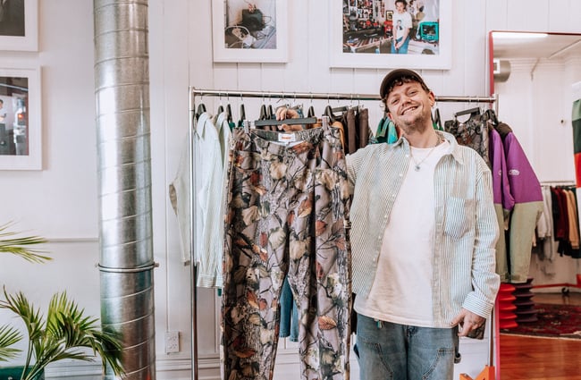 Person holding up and item of clothing and smiling.