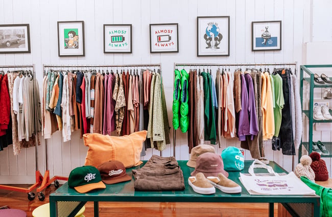Interior image of Checks clothing store with a table of hates and shoes.