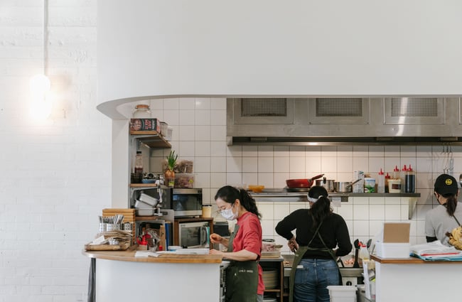 Chefs in the while tiled open kitchen at Child Sister.
