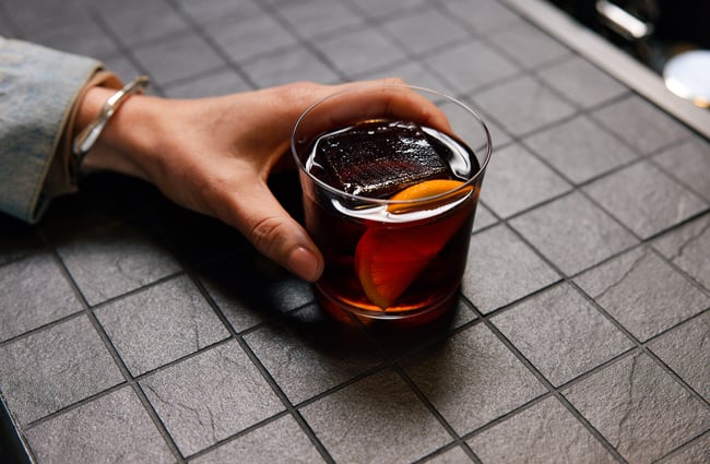 Customer holding a cocktail at Ciao within The Welder.