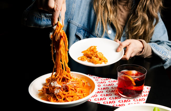 Customer dishing up a plate of spaghetti at Ciao within The Welder.