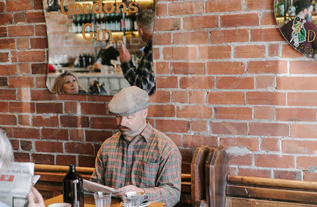 A staff member reading the paper inside at Civil and Naval.