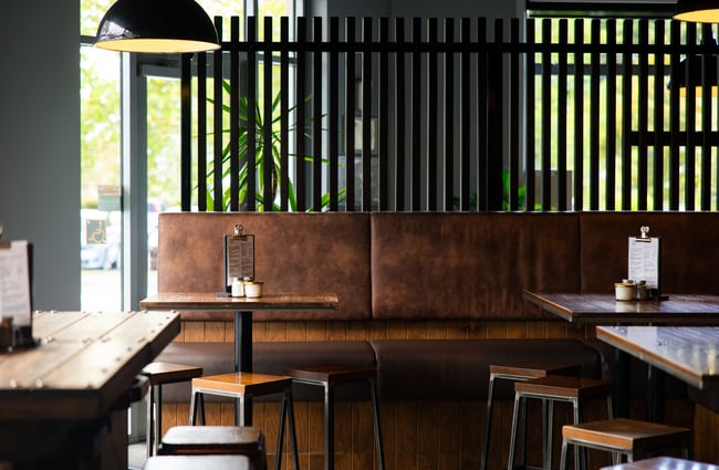 Wooden leather bench seat inside a restaurant.