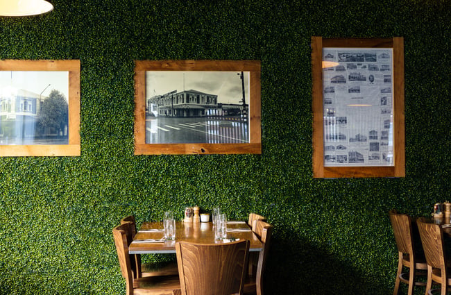 Black and white photos on a fake green wall.