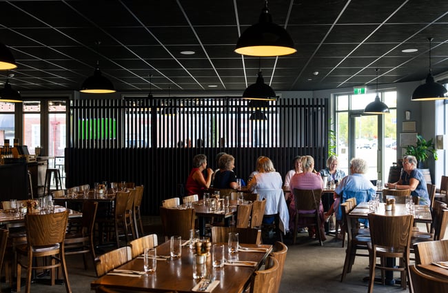 Groups of people dining inside a large restaurant.