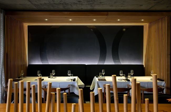 A row of tables and chairs inside a restaurant.