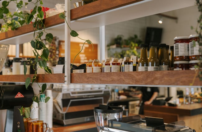 Shelves full of sauces and pot plants.