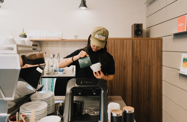 Barista pouring milk into coffee cup at Coffee Embassy Cashel Street in Christchurch