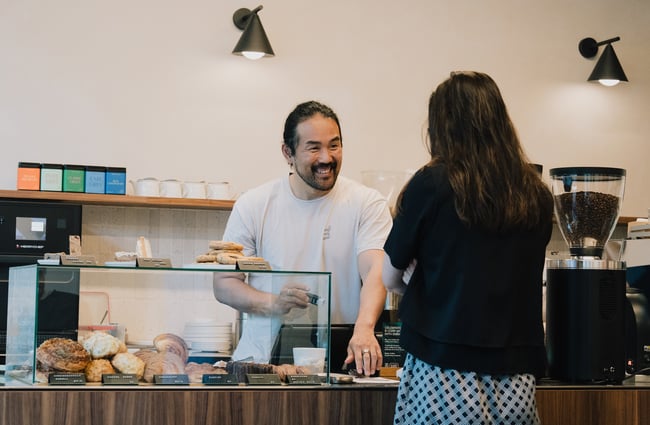 Man smiling at customer behind counter at Coffee Embassy Cashel Street in Christchurch