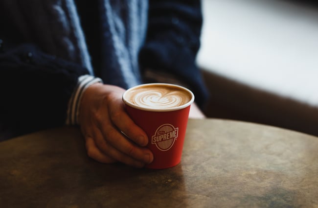 Hand holding red cup of espresso at Coffee Supreme Midland Park, Wellington.