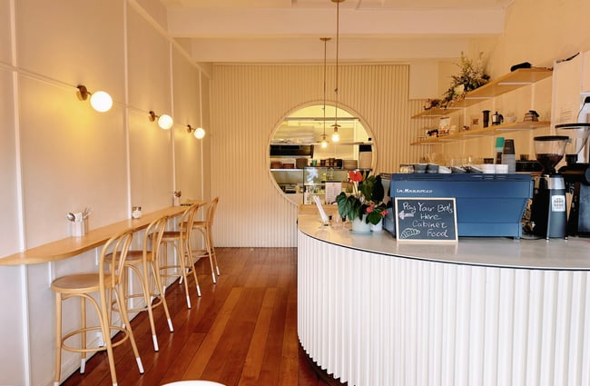A high leaner with chairs runs the length of wall opposite the counter at Comes & Goes café in Petone.