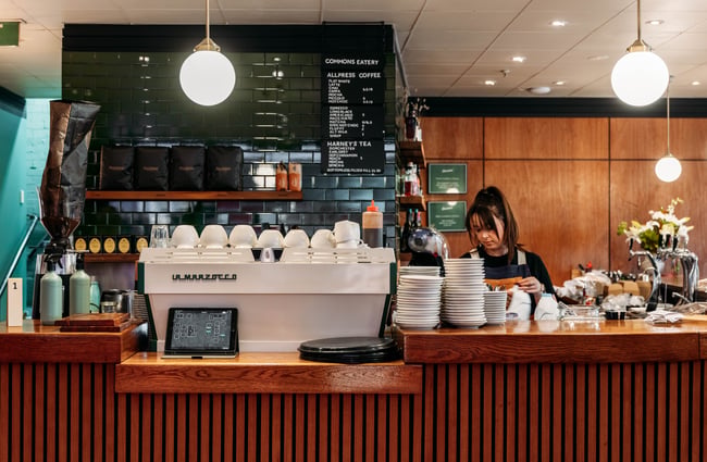 Barista behind the coffee machine at Commons Eatery.