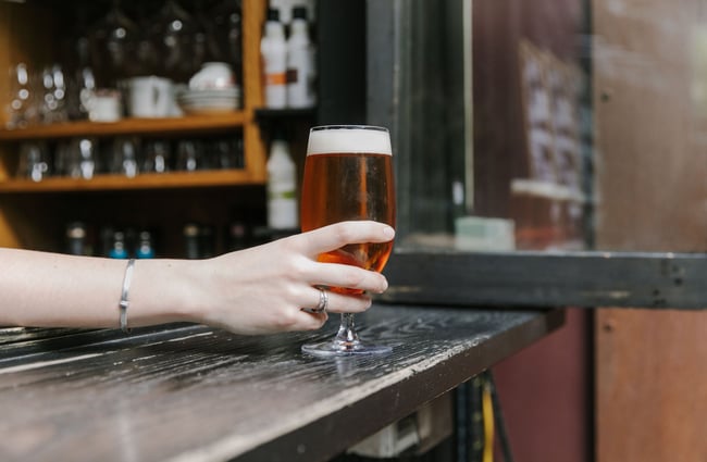 Woman's hand holding a beer at Cork, Wānaka.