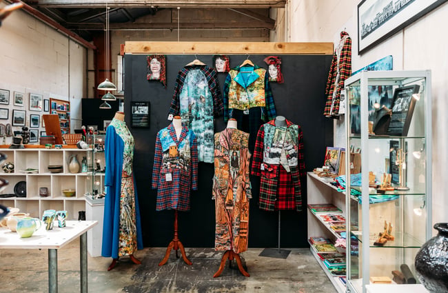 Handmade clothing on mannequins depicting different scenes mixed in with plaid patterns