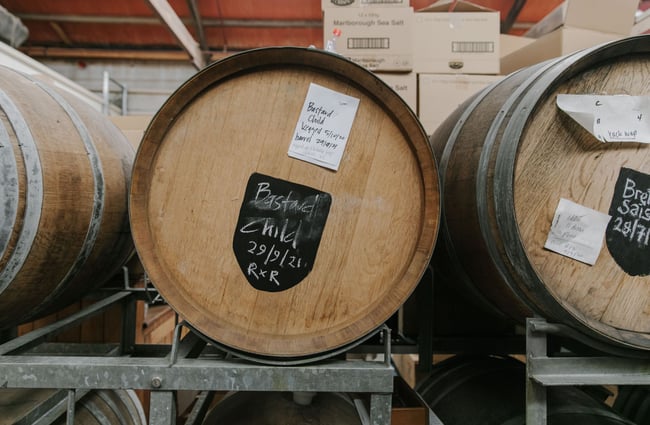 Big wooden barrels staked on top of each other storing some of the Craftwork Brews.