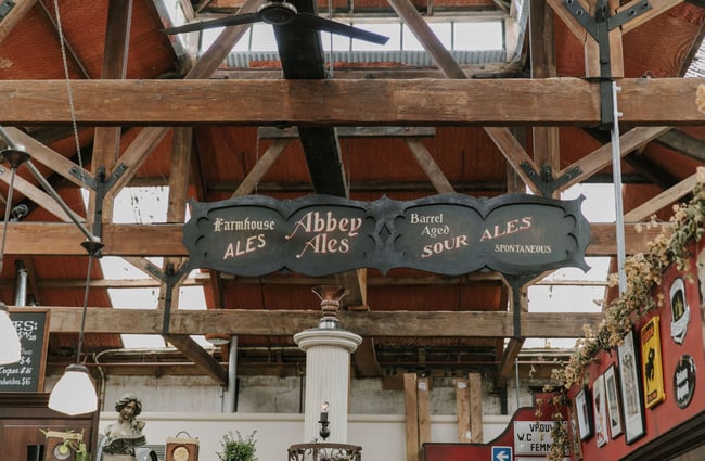 A vintage style sing with four different brews written on it in chalk.