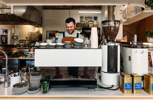 Man smiling as he works the coffee machine at Cream Eatery in Hamilton.