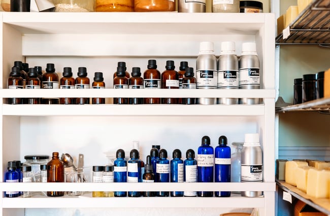 A close up of small blue and clear bottles on shelves.