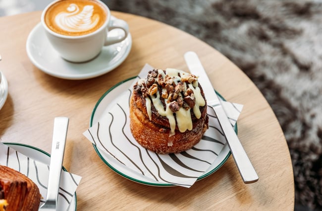 A cup of coffee and a pastry on the table at Crumb.