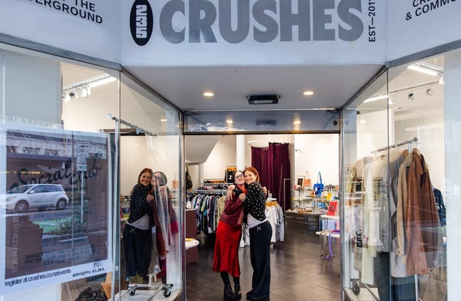 Two women under a 'Crushes' sign.