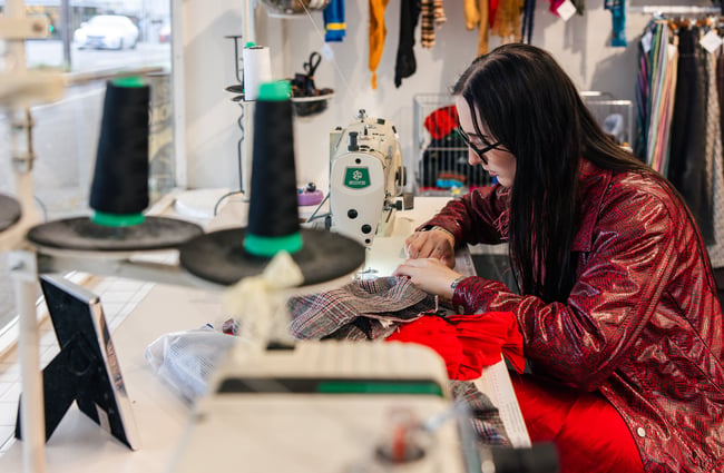 A close up of a woman sewing.