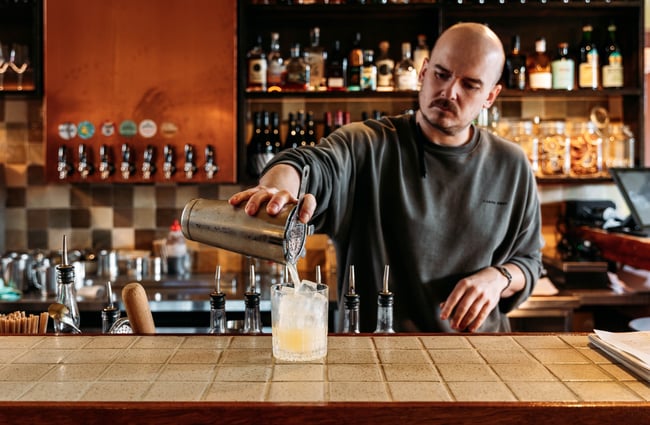 Bartender pouring a drink at Cuba St Tavern.