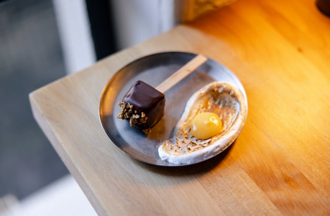 A chocolate cake next to a poached egg on a plate.