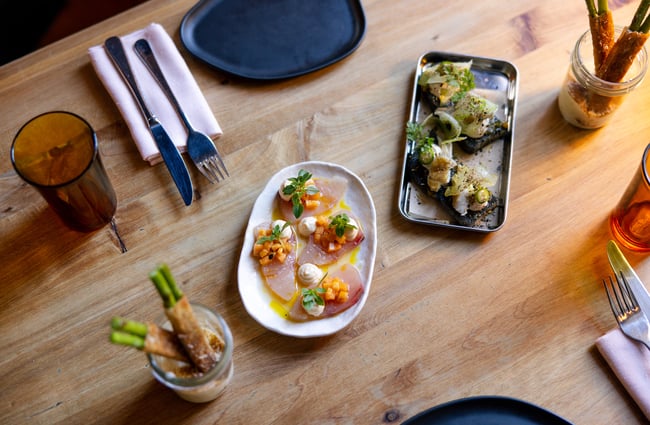 A birds eye view of plates of food on a wooden table.