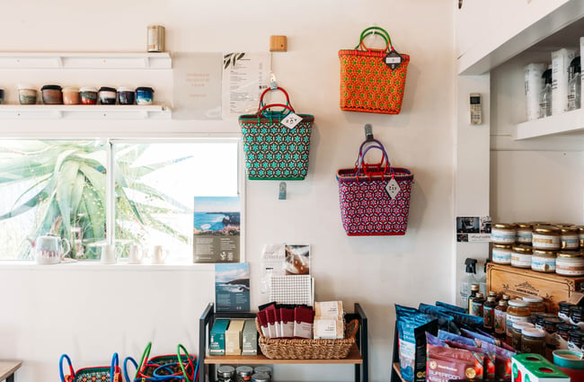 Colourful bags handing up on wall inside a cafe.