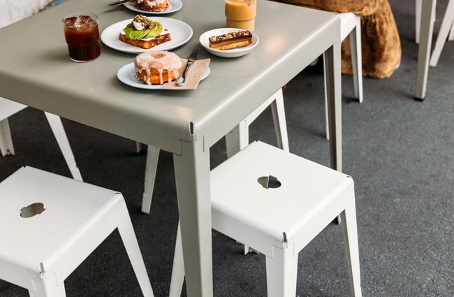 A close up of plates of food and coffee on an outside table.