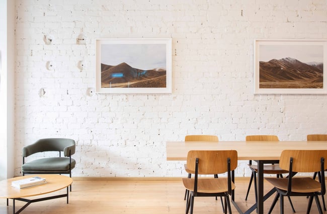 Tables and chairs set up against a white brick wall.