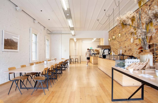 A customer walking inside a large cafe space.