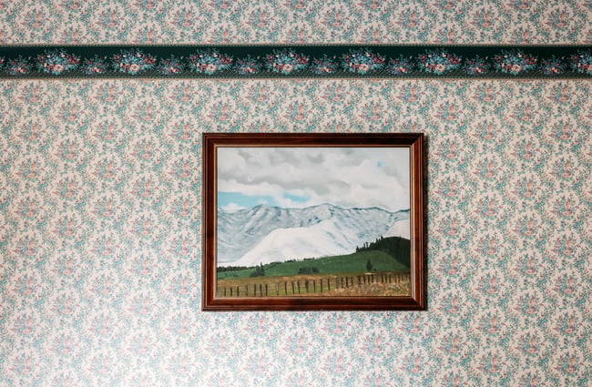 A snowy mountain landscape painting on a wall.
