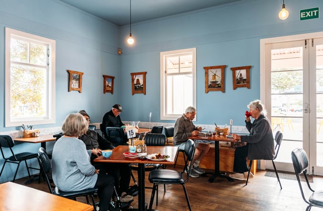 Customers sitting at tables in the cafe area at De Molen.