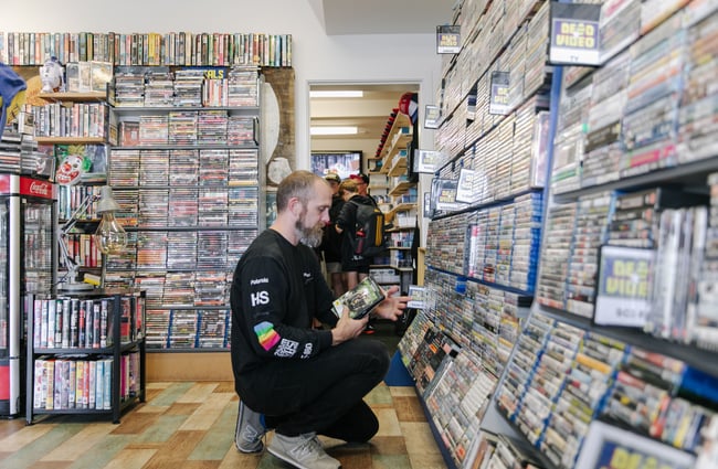 Evan putting away DVDs at Dead Video in Lyttelton.